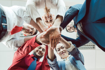 Team of diverse business people stacking their hands together